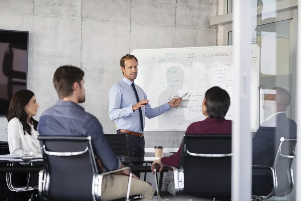 Persoon presenteert aan groep voor whiteboard